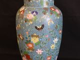 a blue vase with flowers on it on a black background