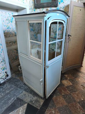 une armoire bleue avec une porte vitrée, dans un coin de la pièce