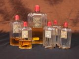 quatre flacons de parfum posés sur une table devant un fond marron