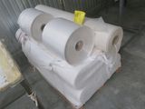 several rolls of paper are stacked on a pallet in a warehouse