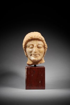 a roman marble head of a man on a wooden stand