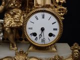 a gold clock with a statue on top of it