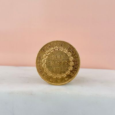 a close up of a gold coin sitting on top of a marble counter