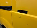 a close up of a yellow van with a sticker on it