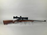 a rifle with a scope mounted on the side of it