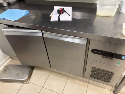 plan de travail en acier inoxydable dans une cuisine professionnelle équipée d'un lave-vaisselle et d'un lave-vaisselle