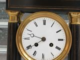 a black and gold clock with roman numerals on it