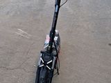 a scooter that is sitting on the ground in the parking lot