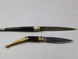 two different types of knives sitting on a table