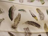 many different colored feathers on a sheet of paper