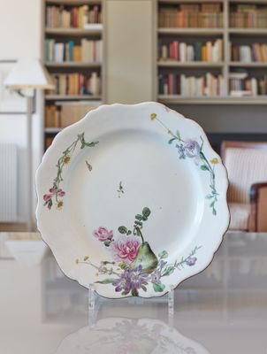 a white plate with a bird on it sitting on a table