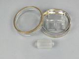 a small glass container with a ring inside of it