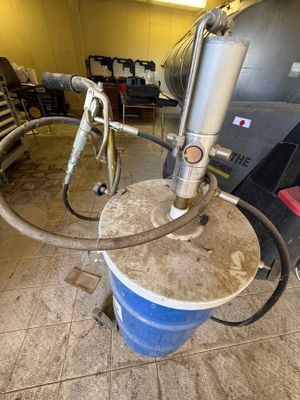 un seau bleu auquel est raccordé un tuyau, dans un garage