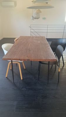une table en bois entourée de quatre chaises dans une pièce