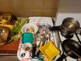 une cuisine équipée d'une cuisinière, d'un évier et de casseroles et poêles posées sur le plan de travail