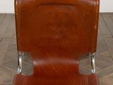 brown leather lounge chair with chrome legs on a herringle floor
