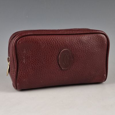 a brown leather toilet bag on a white surface