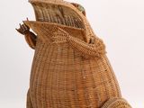 a wicker bag with a frog on it ' s back