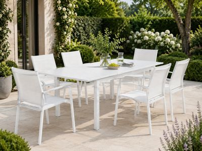 une table et des chaises blanches sur la terrasse
