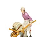 une figurine représentant une femme avec une brouette