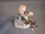 a figurine of a boy with a deer and a bird