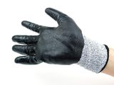 someone is holding a pair of black gloves on a white background