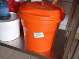 an orange bucket sitting on top of a metal shelf