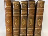 six vieux livres sont empilés sur une table