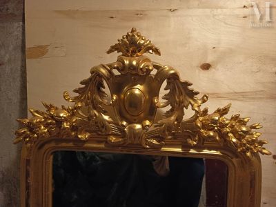 un miroir avec un cadre doré sur le mur