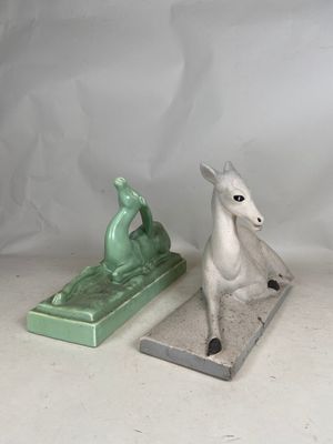 two figurines of a horse and a horse on a table