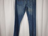 a pair of jeans hanging on a hanger in front of a white curtain