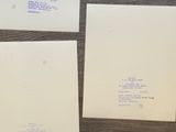 three envelopes and a piece of paper sitting on a table
