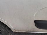 the door of a white car with a hole in the side of it