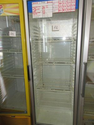 un réfrigérateur à porte vitrée dans un magasin, avec une étiquette de prix dessus