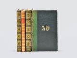 three books are stacked on top of each other on a white surface