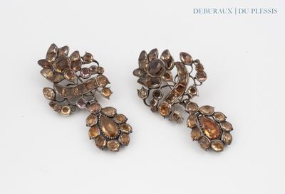 two pairs of earrings with flowers on them on a white surface