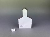 a small paper house with a clock on the front