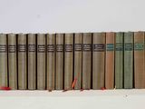 several books are lined up in a row on a white surface