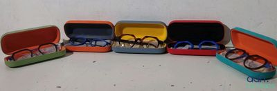 cinq paires de lunettes dans un étui posé sur une table