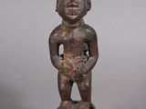 statue of a man holding a bowl of fruit on a wooden base