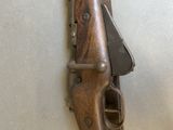 a small wooden gun mounted on a wall next to a wall