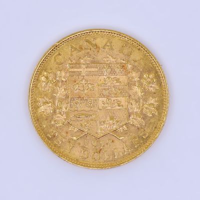 une vieille pièce d'or sur laquelle figure un blason