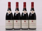 quatre bouteilles de vin rouge sont alignées sur une table