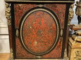 a black and red cabinet sitting on a wooden floor
