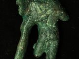 a close up of a green statue of a man holding a dog