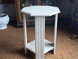 a small white table with a shelf on top of it