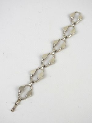 gros plan d'un bracelet en chaîne en argent sur une surface blanche
