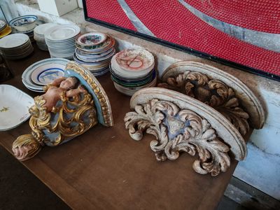 une table sur laquelle se trouvent de nombreuses assiettes et une statue