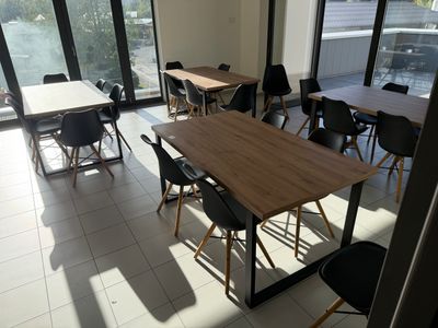 des tables et des chaises dans une pièce dotée de grandes fenêtres et offrant une vue sur la ville