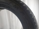 a close up of a tire on a white surface with a white curtain in the background